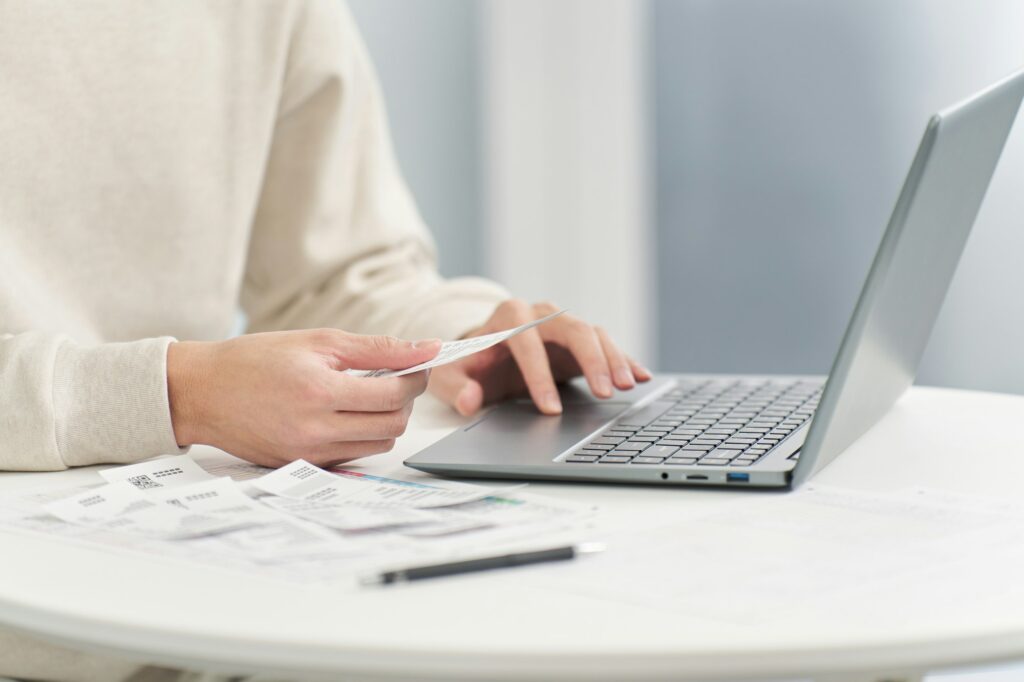 Hand of a man entering expenses into accounting software